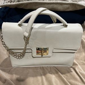 Olivia and Joy. White shoulder purse, thick gold chain and details.